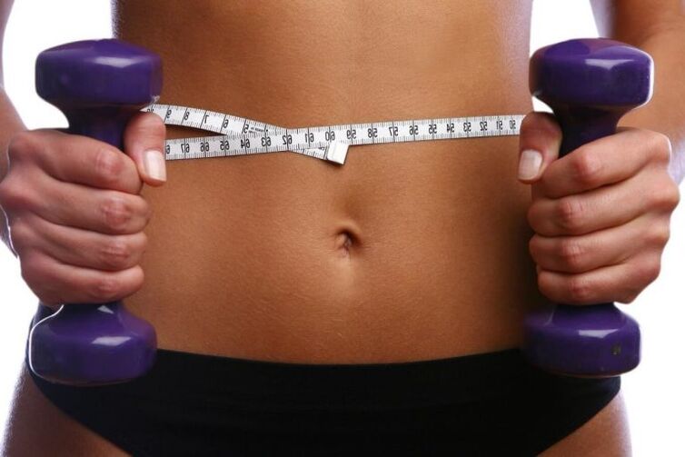 Manubri di fitness nelle mani di una ragazza in forma